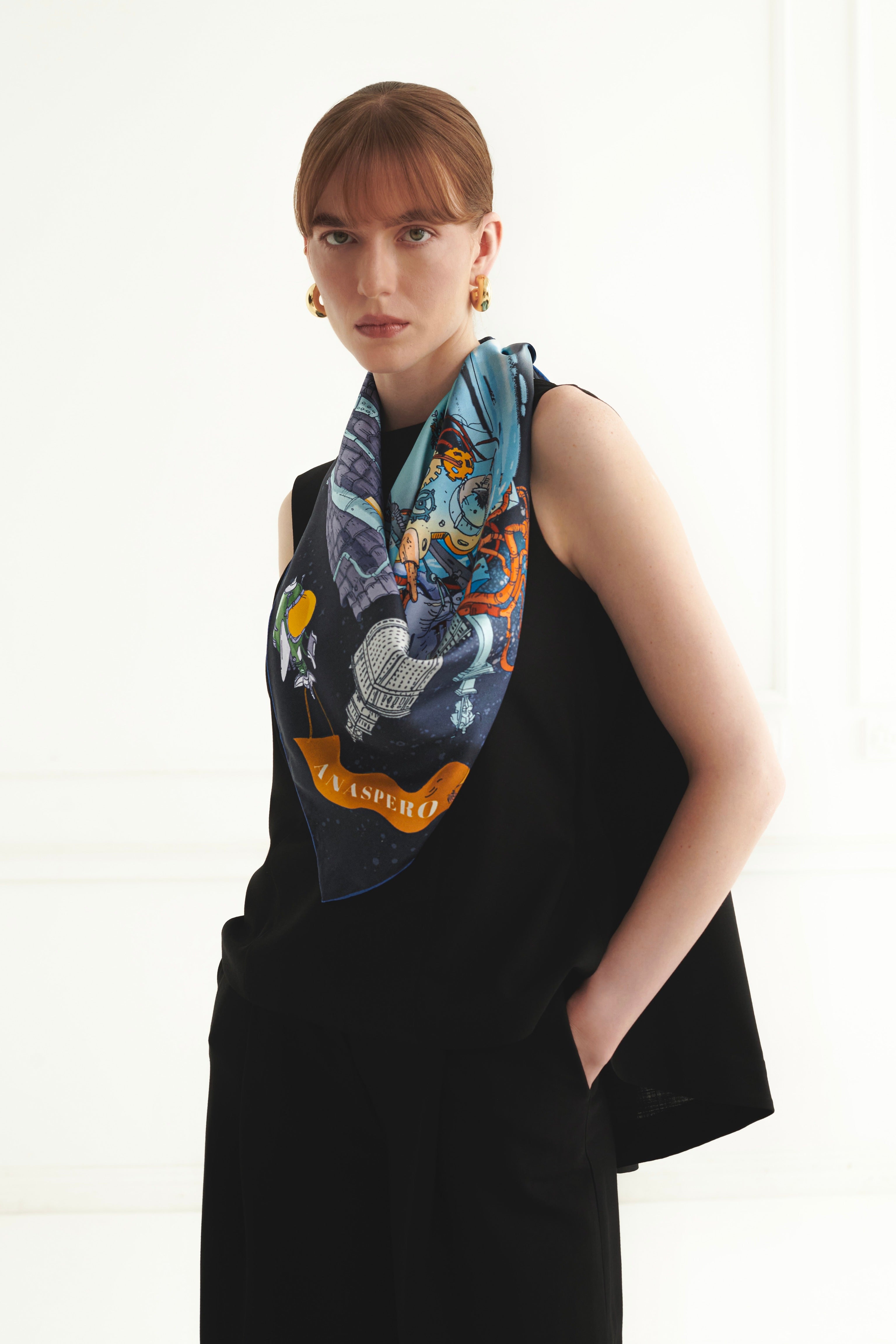 Woman wearing a black sleeveless top with a colorful scarf around her neck on a white background