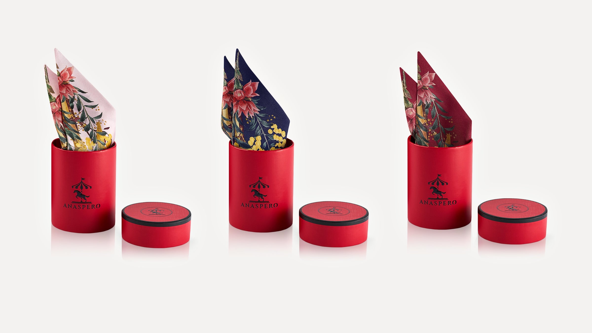 Set of red cylindrical boxes with floral scarves on a white background