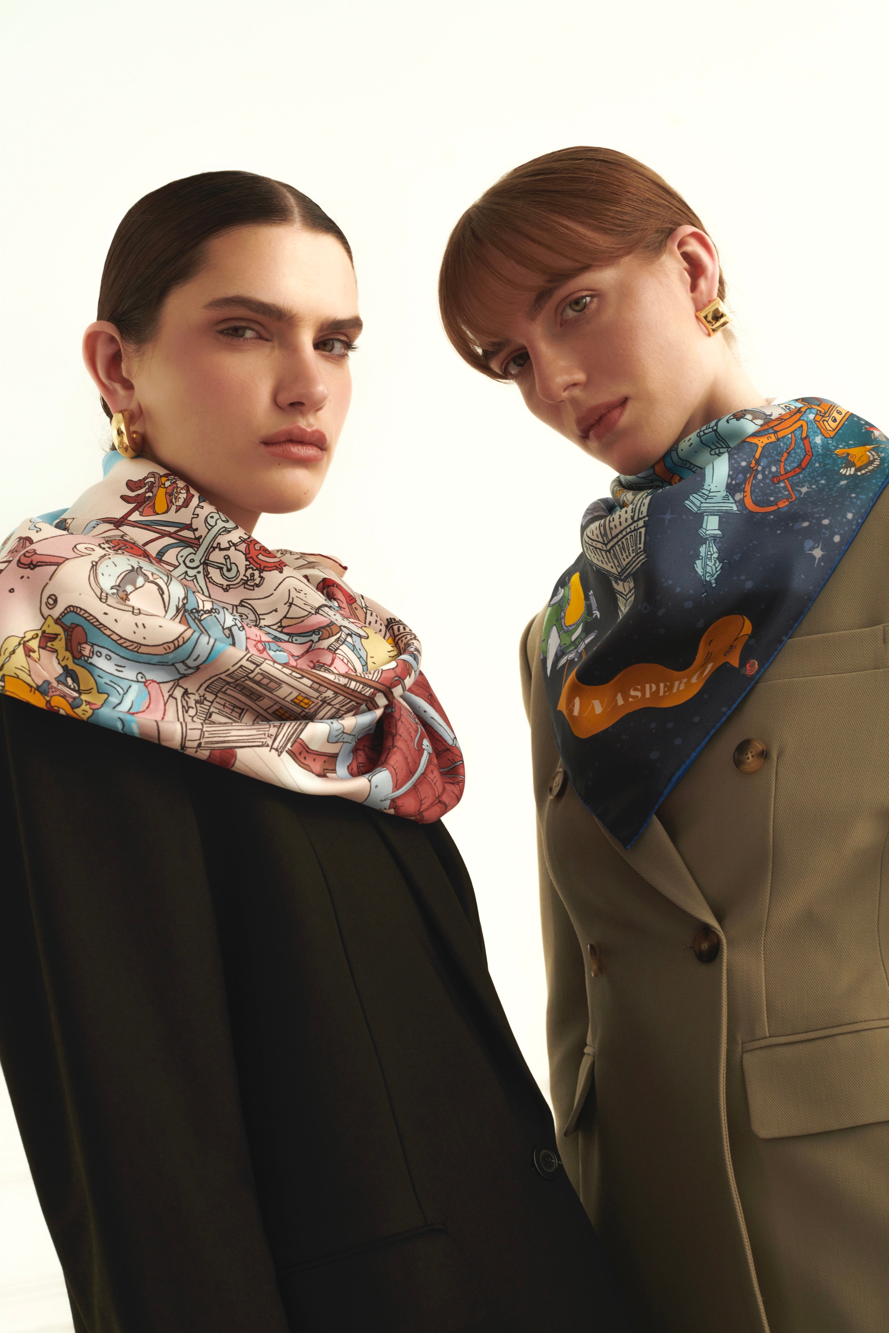 Two women wearing patterned silk scarves on a white background